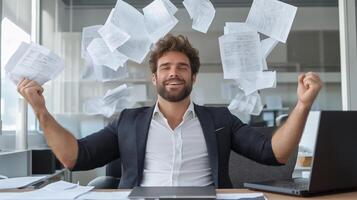 Contented man in a business suit leans back in his chair, raising his hands up, and documents fly around him. An atmosphere of happiness, success and liberation from work in a modern office. photo