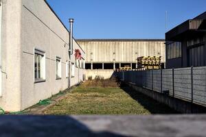 Strip of a garden between buildings with an abandoned warehouse in the background photo