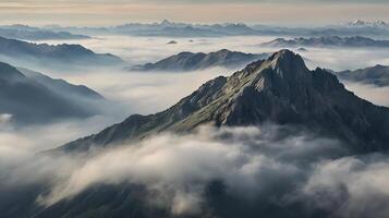 a misty mountain range with peaks emerging photo