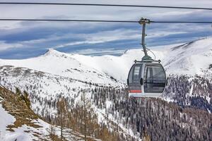 Scenic gondola ride in the alpine high mountains photo