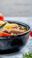 Hearty bowl of vegetable stew brimming with fresh ingredients and flavorful seasonings on a rustic wooden table photo