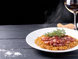 A sophisticated plate of food accompanied by a glass of wine set on a table for a luxurious and memorable dining experience photo