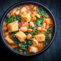 A bowl of flavorful soup generously topped with soft tofu pieces served on a table for a wholesome and healthy meal photo