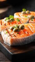 Savory piece of salmon artfully presented with olives on a white plate surrounded by fresh ingredients for a gourmet dish photo