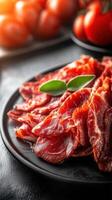 Plate featuring juicy meat accompanied by fresh juicy tomatoes offering a delicious and colorful dining experience photo