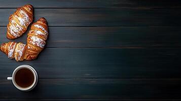 Freshly brewed cup of coffee accompanied by two flaky croissants perfect for an enjoyable morning ritual or snack break photo