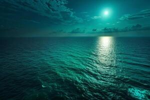 Peaceful ocean view under a glowing moon, soft ripples on the water, and dramatic clouds reflecting in the turquoise sea photo