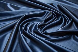 Smooth and rich midnight blue satin fabric swirling in soft folds, creating a high end, elegant background for various uses photo