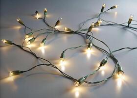 A string of bright fairy lights scattered across a white background, offering a warm and inviting feeling perfect for special occasions photo