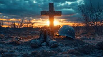 Grave with boots helmet and cross. Setting sun in background. Showing respect. Peaceful landscape. Field with sky. Memorial scene. photo