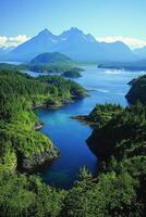 Mountain peaks above forested isles and blue inlet. View from above scenic landscape. Green trees frame water and rocky shores on bright summer day. photo