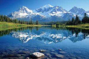 Mountain peaks reflect in still lake. Evergreen trees line water. Clear blue sky above snowy mountain range. Natural landscape background. Serene nature scene. photo