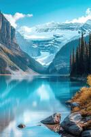 Calm blue lake view. Mountains rise in the distance. Snow covers the peaks. Trees line the shore. Rocks sit in the water. photo