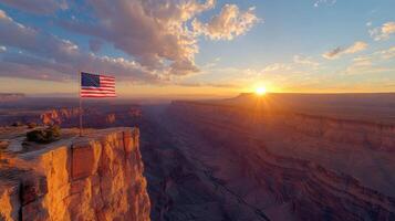 American flag on cliff edge at sunset. Canyon landscape. Red rock formations. Beautiful sky with clouds. Sunshine over grand canyon. National symbol waving. photo