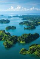 Green islands rest on blue water. Sky has clouds. Tropical nature. Landscape shows paradise. Many islands show beauty. View from high shows the area. photo