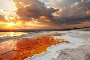 Glowing colors and steam from a hot spring surrounded by mountains under a dramatic sky with warm, golden hues, abstract background photo