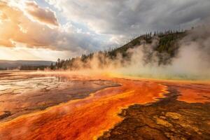 sunlit landscape with steam rising from the ground, yellow and orange colors create an abstract, ethereal atmosphere, abstract background photo