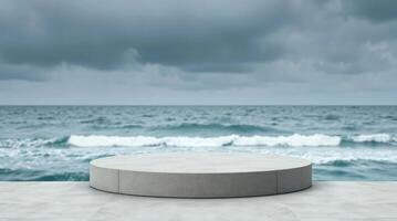 An empty podium sitting on a concrete floor in front of the ocean photo