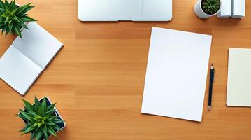 An overhead view of a desk with a laptop, notepad, and plant photo
