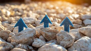Three blue arrows pointing up on a rocky field photo