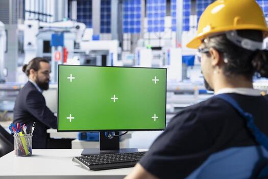Photovoltaics facility worker reviewing efficiency metrics on green screen computer to improve production output. Solar panels plant specialist identifying system errors using chroma key PC photo
