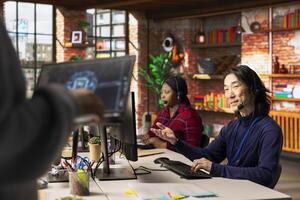 Call center multiethnic team using artificial intelligence chatbot to provide multilingual support. Multiracial customer support colleagues leveraging AI tools to translate clients interactions photo