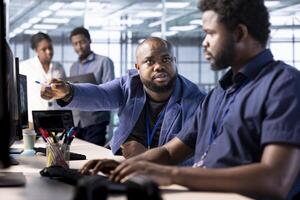 Manager admonishing data center engineer using programming languages to construct algorithms and build applications. Server hub supervisor scolding worker unable to properly optimize code photo