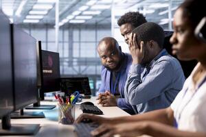 Team of programmers in server farm upset after losing all data after hacker managed to pass firewall. Critical error alert on monitor in data center making IT staff members feel dejected photo