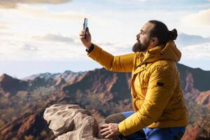 Hiker adventure seeker captures the breathtaking scenic view at the top of mountain, gazes at a distant mountain range and embraces beauty of the wilderness. Joy of discovering wonders. photo