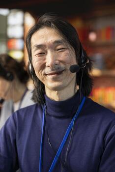 Portrait of cheerful senior call center agent dealing with unhappy customers, speaking with them using headset in office. Jolly experienced customer support representative handling clients complaints photo