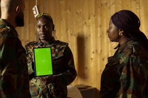 Soldiers at shooting gallery watching on mockup tablet, participating in marksmanship training program. Military units looking at instructions on isolated screen device during shooting course photo