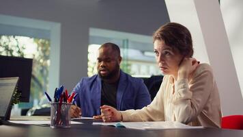 Car dealership salesman giving couple documentation to read after agreeing terms. Agent giving sale contract for clients to sign after they decide to make purchase, camera B photo