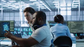Teamworking colleagues updating AI systems, writing intricate binary code scripts on PC and laptop. Team of engineers using programming to upgrade artificial intelligence simulation model, camera A photo