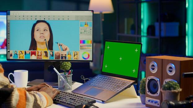 Male graphic artist using essential digital tools next to isolated mockup screen, professional design work showcasing modern setup at home. Designer showing advanced photo editing skills. Camera A.