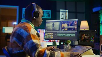 Videographer expert adjusting movie clips on computer at his home, working with color wheel to add visual effects. African american editor making fx montage for post production. Camera B. photo