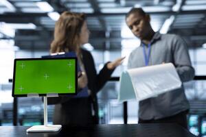 Mockup tablet used by data center engineers in blurry background reviewing equipment diagnostics. Close up of isolated screen device used by workers adjusting server room configurations photo