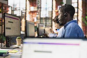 Call center agent tracking shipments in office, looking at PC screen, handling delivery delays. Customer center employee using software to locate clients packages and provide status updates photo