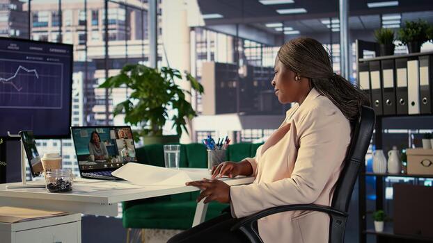 Woman entrepreneur discussing online about a new project with forecast affiliates, sharing insight about sales reports progress and analytics. Leader meeting on videoconference call. Camera B. photo