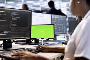 Computer scientist in data center updates rigs systems on green screen tablet to protect servers from exploitable software vulnerabilities. System administrator using mockup device to look for errors photo