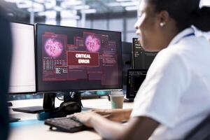 African american computer scientist in server hub working to protect equipment from hacker. Woman in data center establishment in need of help from engineers to fix security breach alert photo