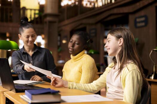 Tutor providing accurate learning materials during academic session with schoolgirls, promoting child development in supportive private lessons. Mentor boosts knowledge with library resources. photo