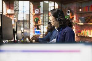 Call center senior agent uses artificial intelligence to enhance customer interaction and resolve inquiries efficiently. Experienced Asian customer service employee using AI communication technologies photo
