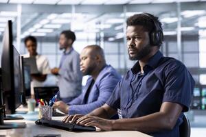 Data center worker hearing songs in headphones while using programming languages to construct algorithms and build applications. Server hub employee listening music, debugging and optimizing code photo