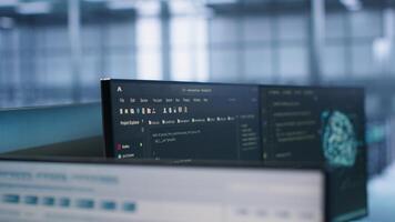 Close up of code on computer screens in high tech facility responsible with intense data computations demanding scalable, error free network to support AI machine learning, handheld camera shot photo