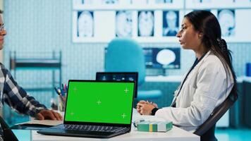 Indian medic consulting her patient in medical facility next to copy space, using advanced technology for scan interpretation and diagnostics. Expert gives advice based on records. Camera A. photo