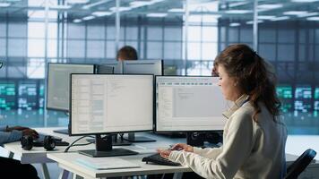 Manager supervising multiethnic team working in data center, making announcement. Team leader discussing with employees monitoring energy consumption across server rigs components, camera A photo