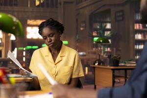 Students team read through an academic project in a vintage library, showcasing their commitment to education and self improvement. Black pupils work together on their academic growth. photo