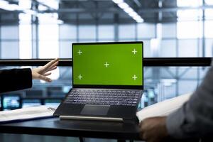 Teamworking technicians in data center use mockup notebook, observing analytics, reviewing equipment health. Server room IT experts using isolated screen laptop, adjusting system parameters, close up photo
