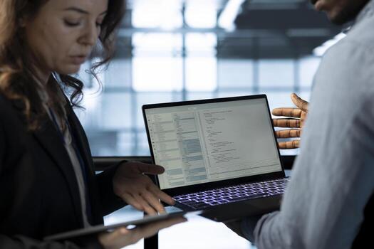 Software developers in data center workspace use laptop to calibrate energy usage. Server room IT professionals code on notebook, doing maintenance on equipment mainframes photo