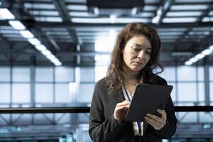 Technician in data center using tablet, conducting security audits, reviewing firewall rules, enforcing cybersecurity protocols, mitigating potential vulnerabilities, logging incident details photo